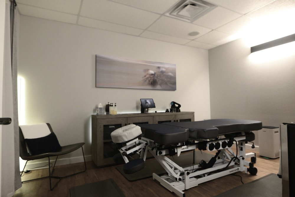 The private treatment room, with an adjustable table and a chair.