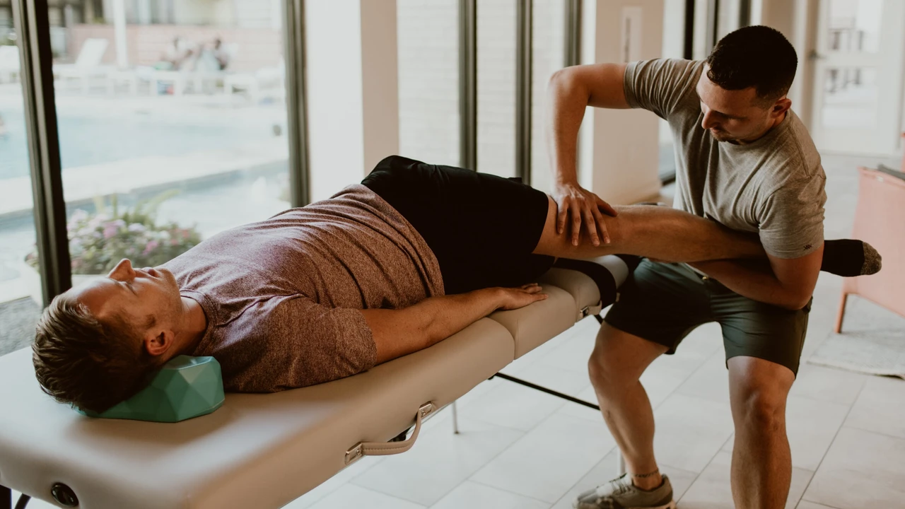 Chris supports Erik's leg during an assisted stretch therapy session.